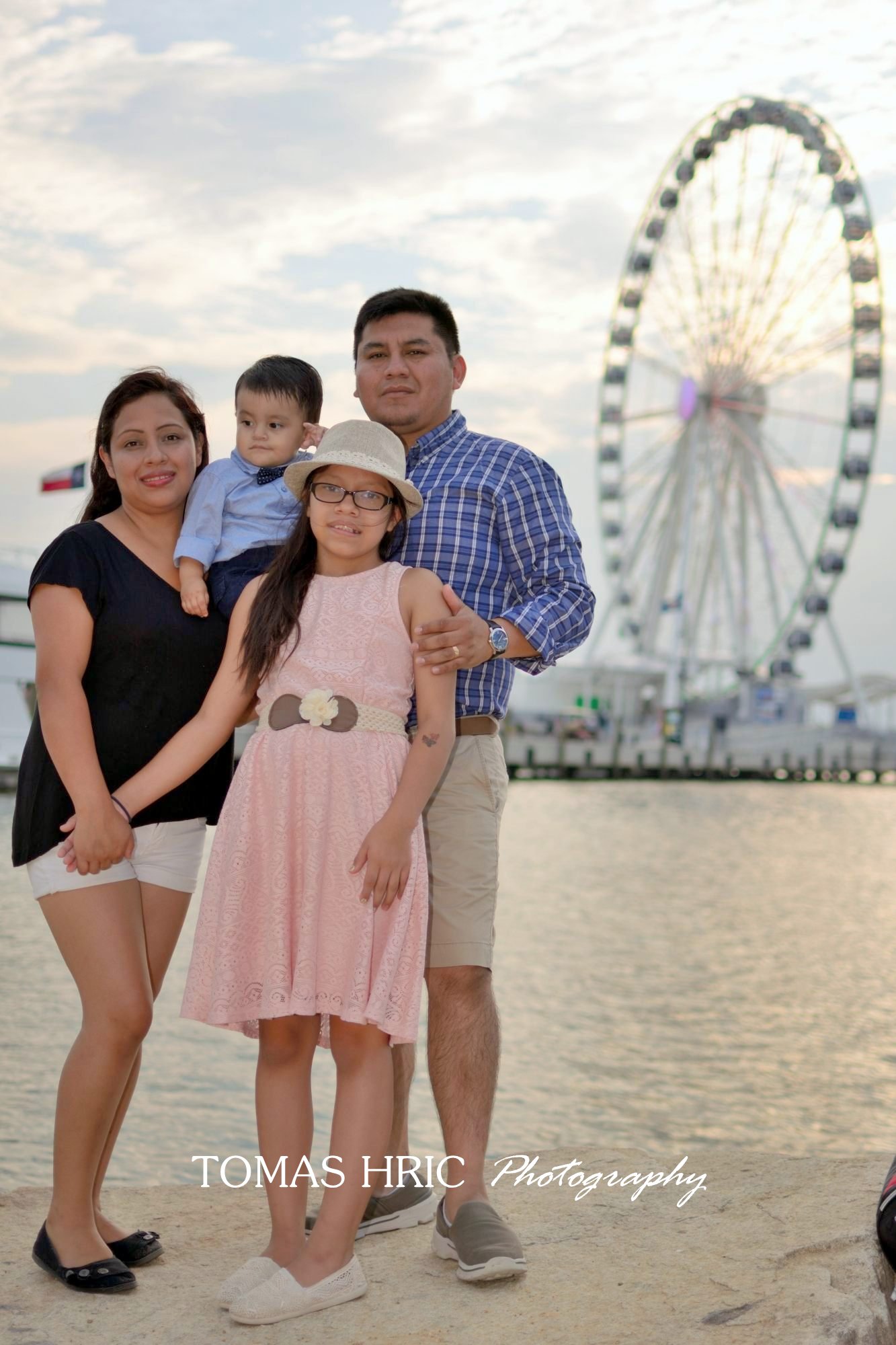 family portrait with 2 children in front of ferris wheel