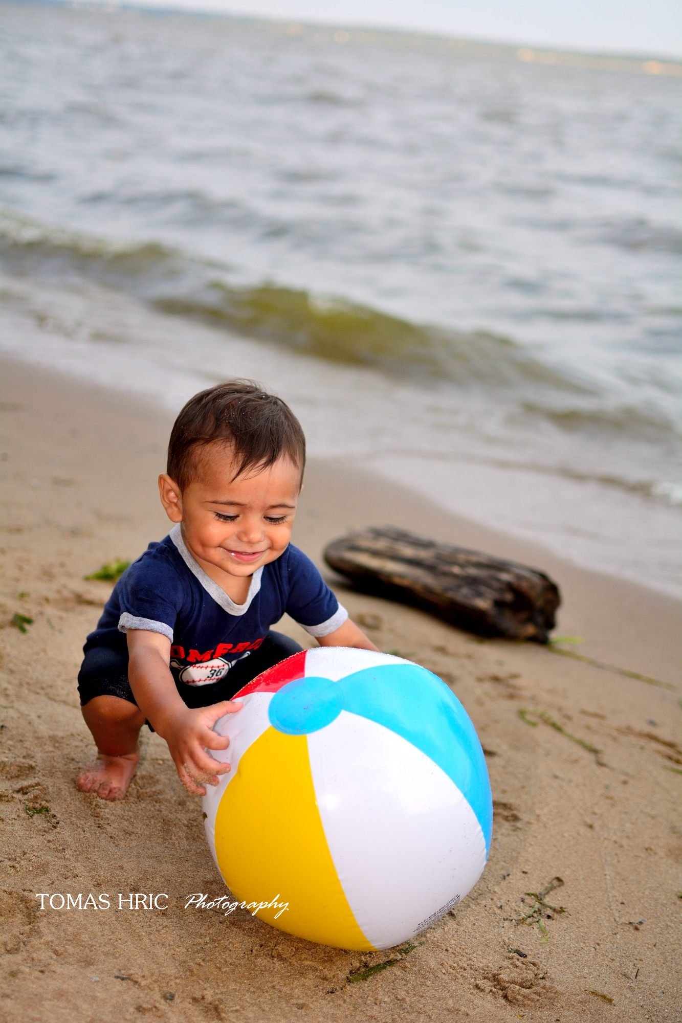 little boy playing with beach ball on the beach