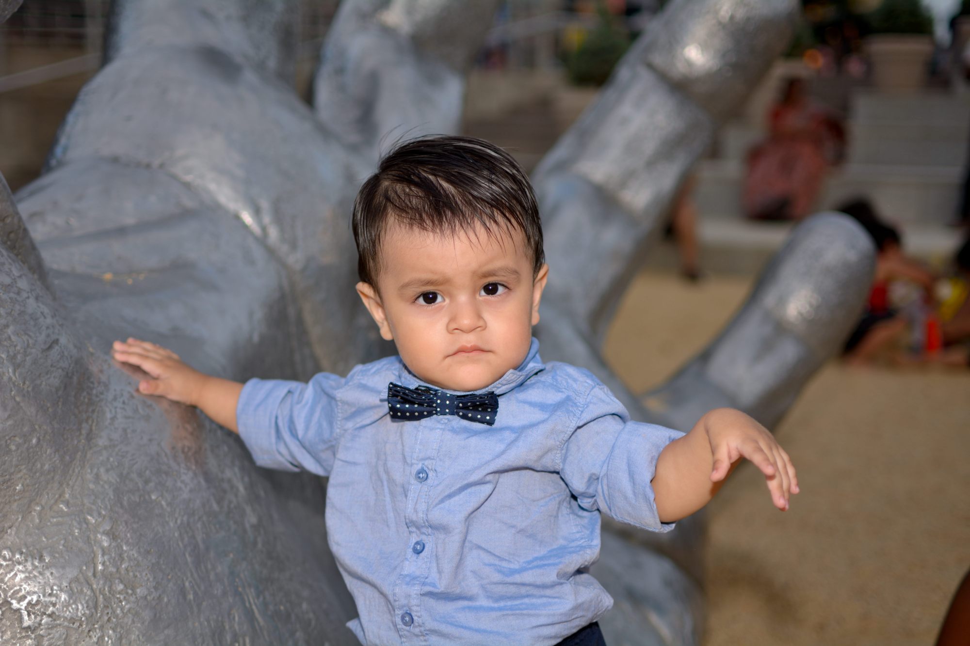 tomas hric photography's stunning family photographer portrait of handsome little boy in front of a giant hand national harbor