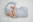 Newborn wrapped in a grey cheese cloth with grey hat